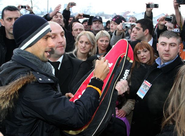 Djokovic, seen here signing autographs for fans in Jagodina, is a national hero in Serbia.