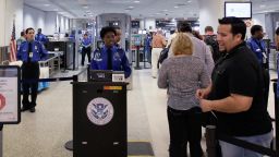 Passengers wait to be screened at a security checkpoint at Miami International Airport.