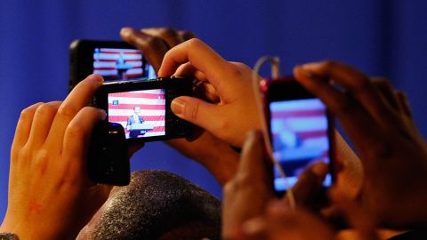 Supporters of U.S. President Barack Obama take pictures with their smart phones.