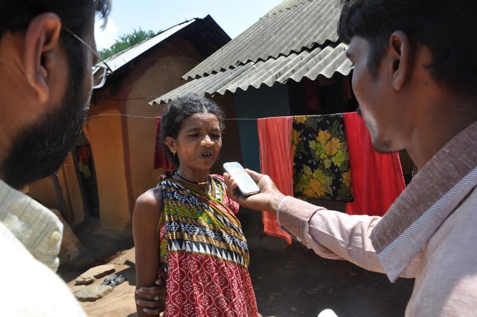 A tribal woman is interviewed by a citizen journalist.