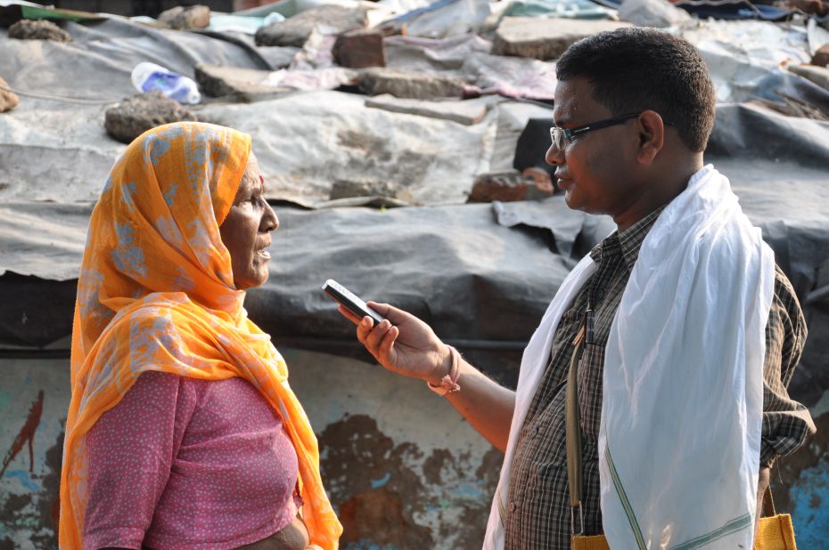 A woman is interviewed in a Delhi slum by a CGNet Swara citizen journalist.