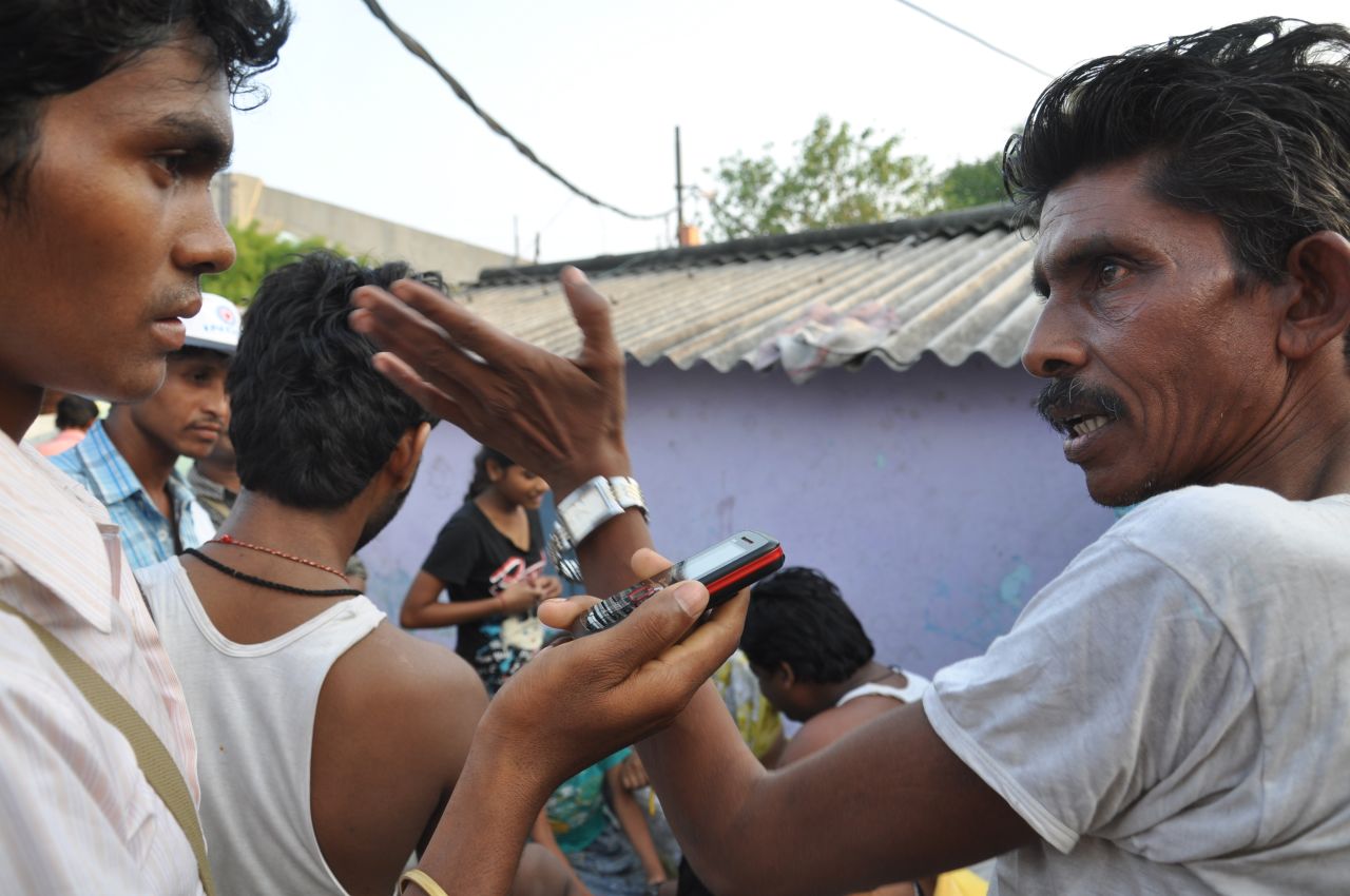 A man is interviewed in a Delhi slum by a CGNet Swara journalist.