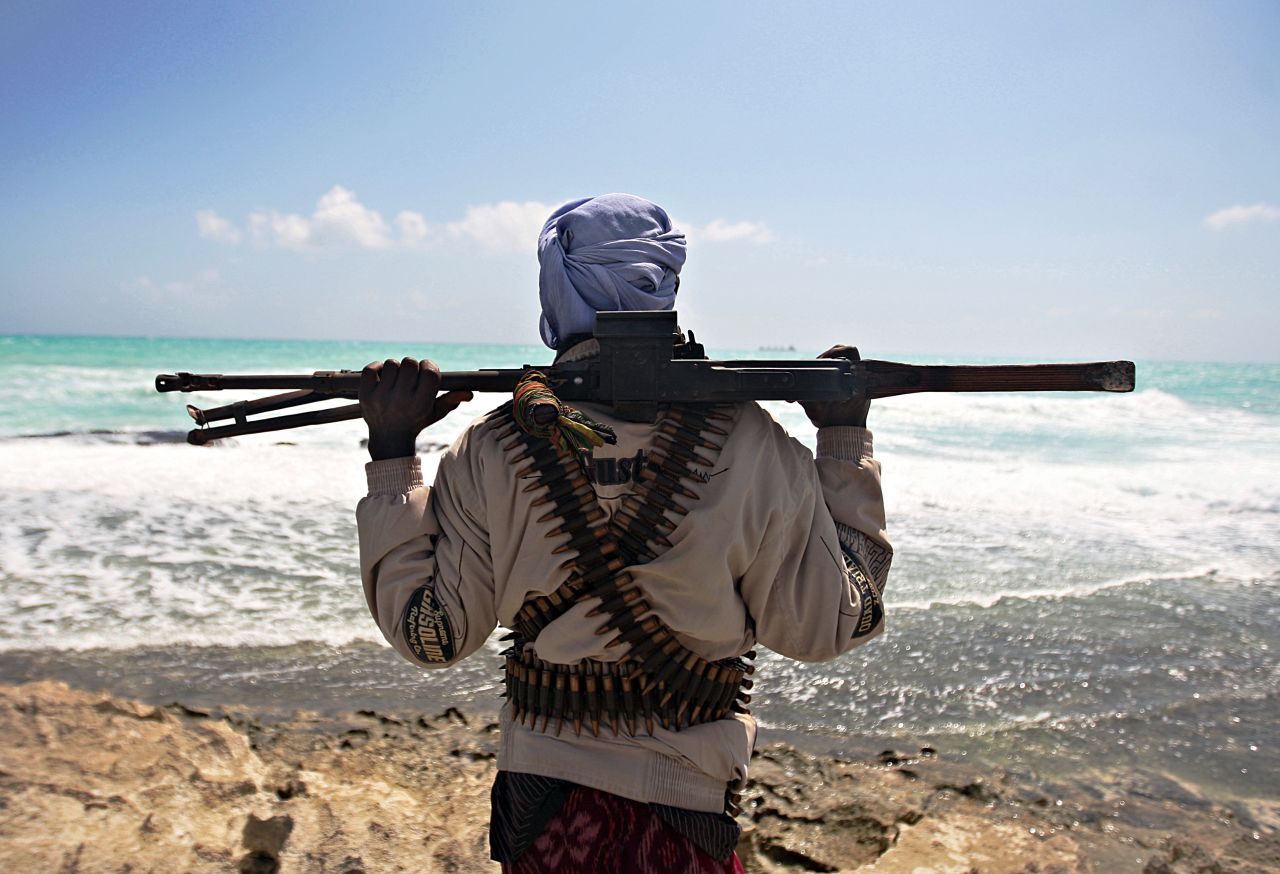 Heavily armed pirates have taken advantage of the nation's lawless coastal waters to become a major threat to international shipping in the area. In this photo, a gun-wielding pirate keeps vigil along the coastline at Hobyo town, north-eastern Somalia, 2009. 