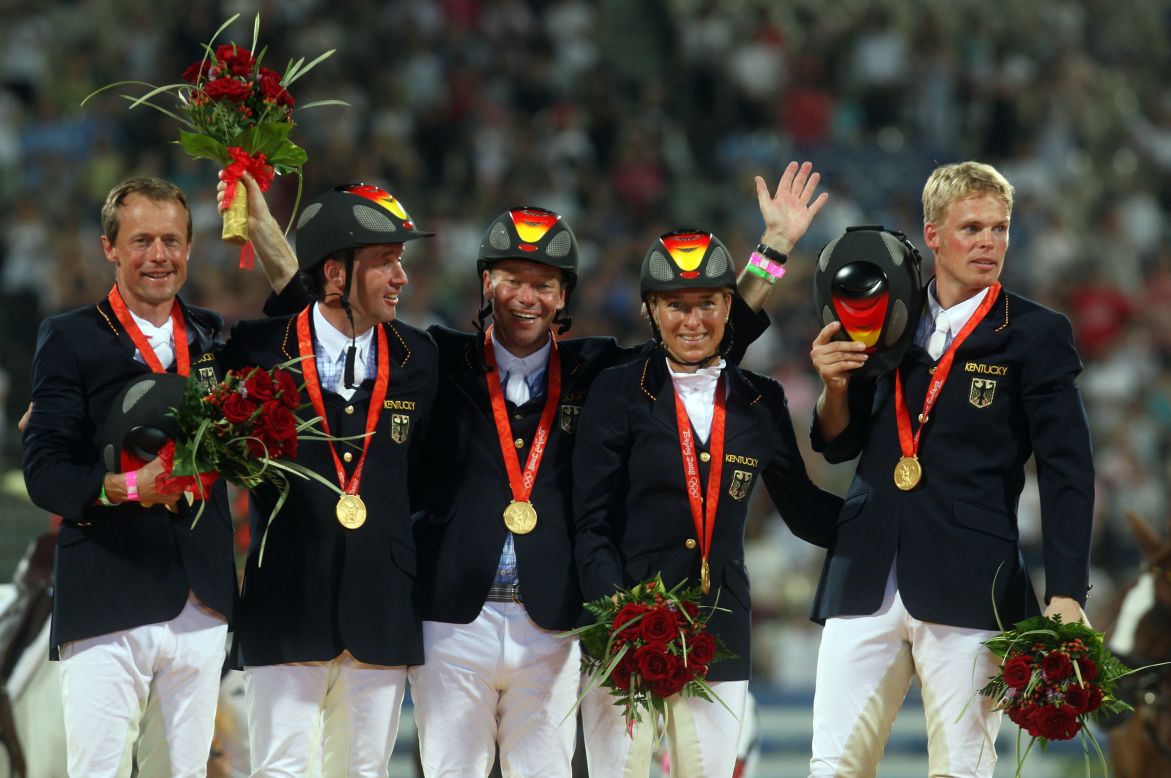 Klimke (second from right) and the victorious German team receive their gold medals at the Beijing Olympics.  Her teammates (left to right) were Peter Thomsen, Andreas Dibowski, Hinrich Romeike and Frank Ostholt. 