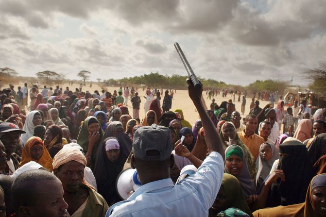 A security officer keeps order in Dadaab as hundreds of desperate people try to move to a less crowded refugee camp set up three days' drive away.