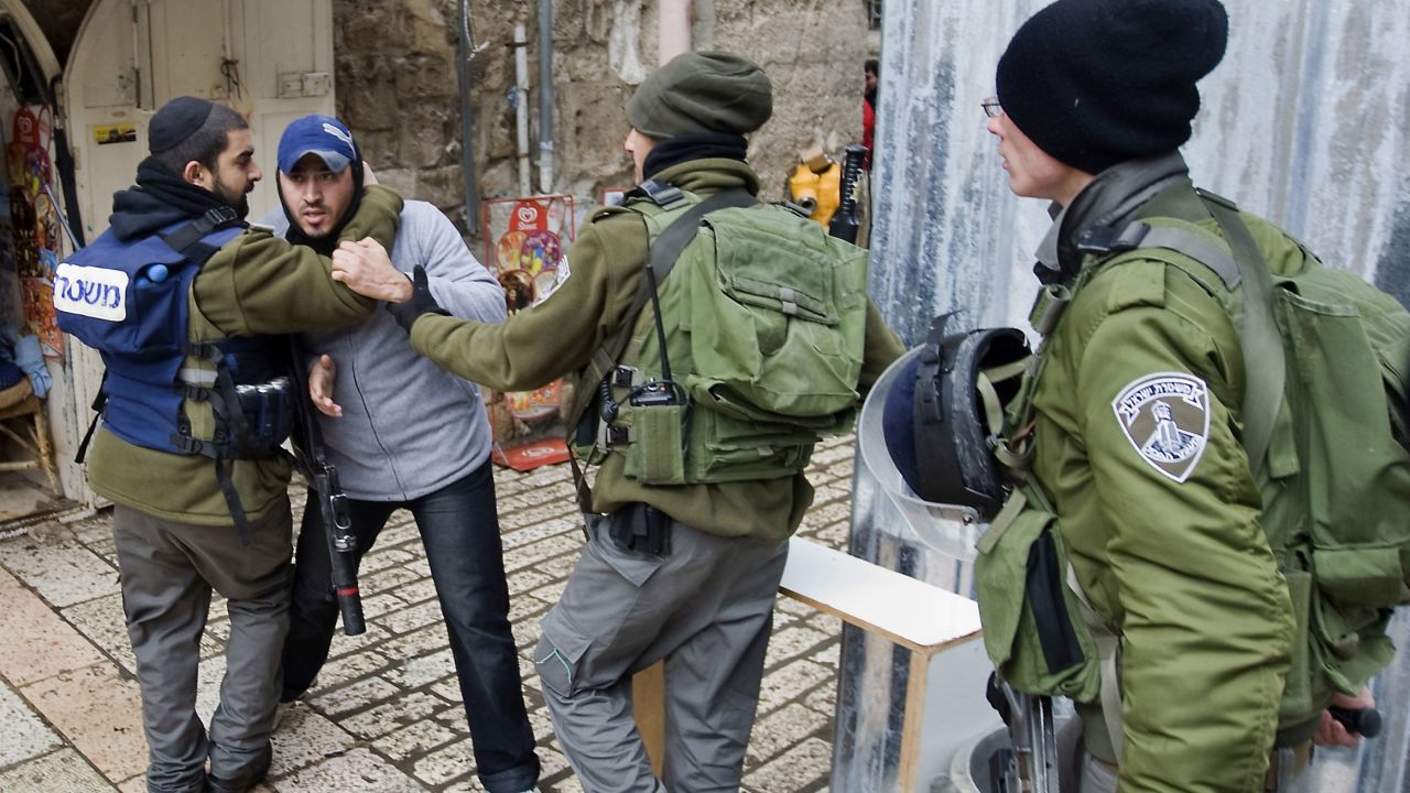 Israeli border policemen detain a Palestinian man outside the al-Aqsa mosque compound on February 19, 2012.
