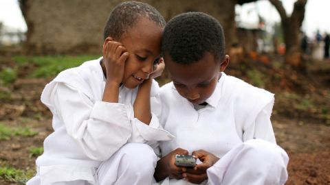 Two boys play with a cellular phone in Ethiopia. Figures show that mobile penetration in Africa is at an all time high.