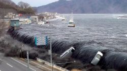 This picture taken by a Miyako City official on March 11, 2011 and released on March 18, 2011 shows a tsunami breeching an embankment and flowing into the city of Miyako in Iwate prefecture shortly after a 9.0 magnitude earthquake hit the region of northern Japan. The official number of dead and missing after the devastating earthquake and tsunami that flattened Japan's northeast coast a week ago has topped 16,600, with 6,405 confirmed dead, it was announced on March 18, 2011. AFP PHOTO / JIJI PRESS (Photo credit should read JIJI PRESS/AFP/Getty Images) 