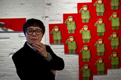 Song Byeok's paintings are often about coming to terms with life outside North Korea. Behind him is the painting "Child Warrior," depicting the curious North Korean custom of dressing children in military clothes on special birthdays. Song painted the boy with his eyes closed. 
