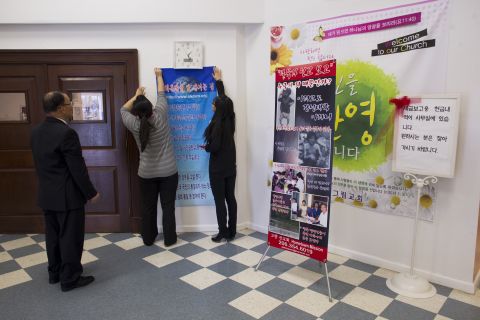 JinHye and EunHye regularly advocate for human rights issues in North Korea. They hang signs for a church program thanking those who helped them adjust to life in the United States. 