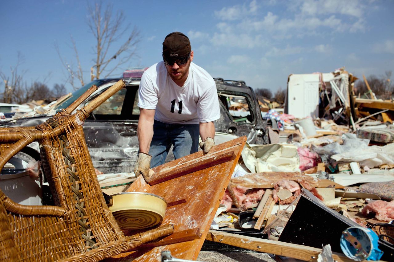 Douglas Osman sifts through the wreckage of his grandmother's house Wednesday in Harrisburg. His grandmother, Mary Osman, was one of six people killed in the Illinois town.