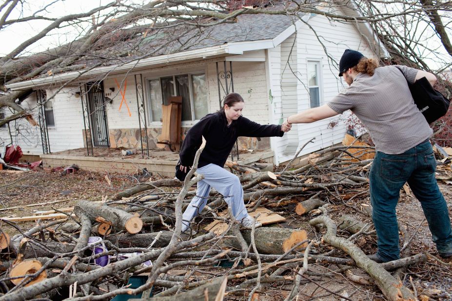Levi Fogle helps girlfriend Sarah Pearce leave a damaged house in Harrisburg. Fogle, Pearce and her three daughters went unharmed in the storm.
