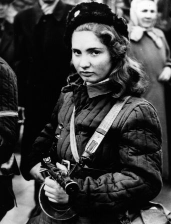 A 15-year-old Hungarian girl armed with a machine gun during protests against the country's communist rulers. 