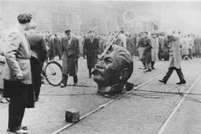 Protesters mill around a decapitated statue head of former Soviet leader Joseph Stalin on the streets of the Hungarian capital Budapest.