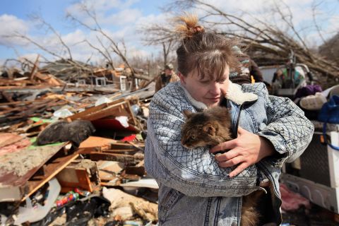 Zollman hugs her cat Thumbelina after it was pulled from the debris of her home.