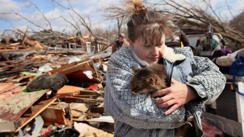 Zollman hugs her cat Thumbelina after it was pulled from the debris of her home.