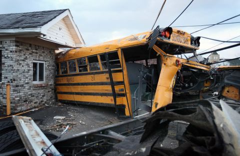 A school bus is lodged in a home in Henryville where it came to rest after being tossed by Friday's tornado.