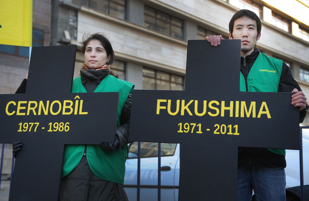 Greenpeace activists hold black crosses. one reading "Fukushima" nuclear power plant and the other, "Chernobyl," at a protest in Bucharest March 5.