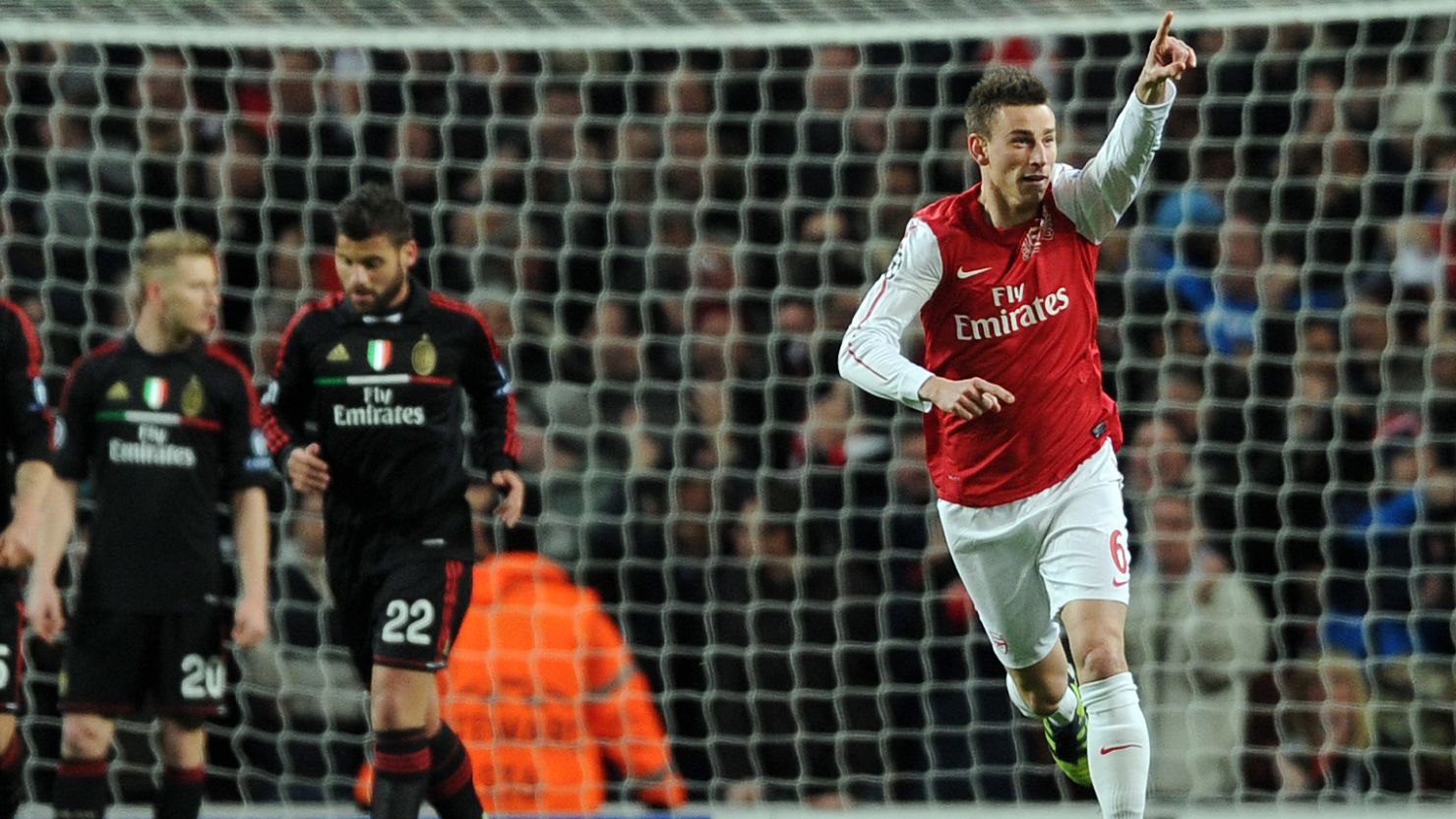 Laurent Koscielny celebrates his opening goal in Arsenal's 3-0 win but AC Milan went through to the last  eight.         
