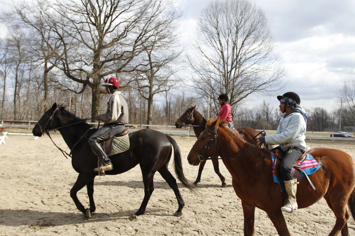 Leshaun Walker, Sihgerra Myers and Sydney Rutledge exercise horses in a paddock at the Chamounix Equestrian Center in Philadelphia's Fairmount Park, home to the Work To Ride long-term prevention program for middle- to high-school-aged youth. 