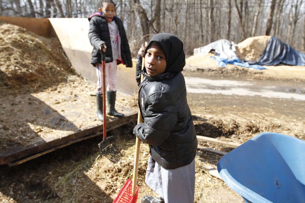 Sudayaah Myers, 9, finishes her Saturday chores, including cleaning out horse stalls and dumping manure, alongside fellow rider, Aniyah Foreman, 9. "I like coming here, we have a lot of fun," she said. 