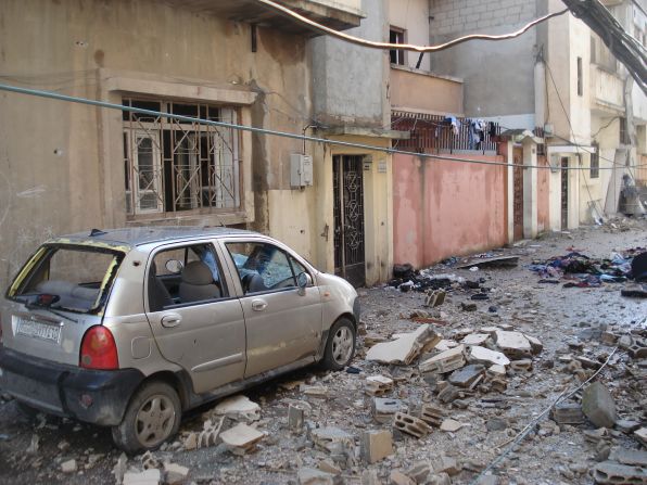 A bombed out car and rubble covers the ground in this street Homs, Syria, where the army has been attacking anti-regime elements.