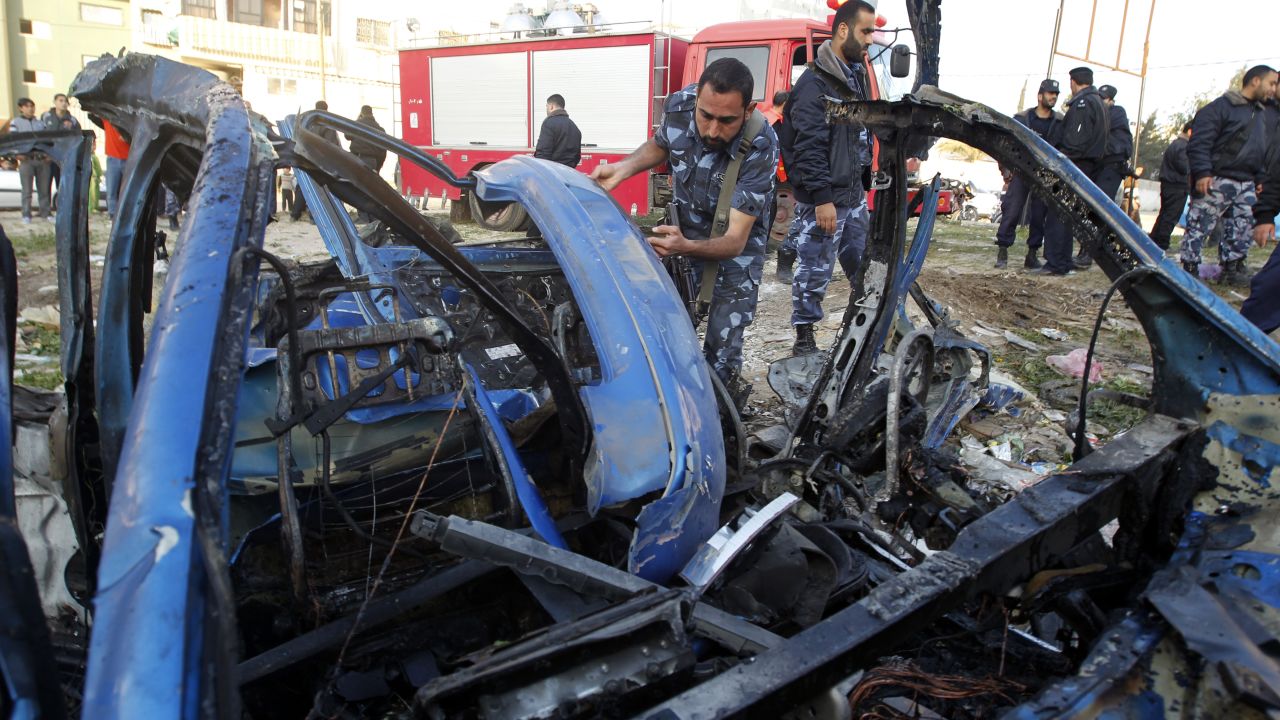 A Hamas policeman inspects the remains of a vehicle that was targeted by an Israeli airstrike in Gaza City.