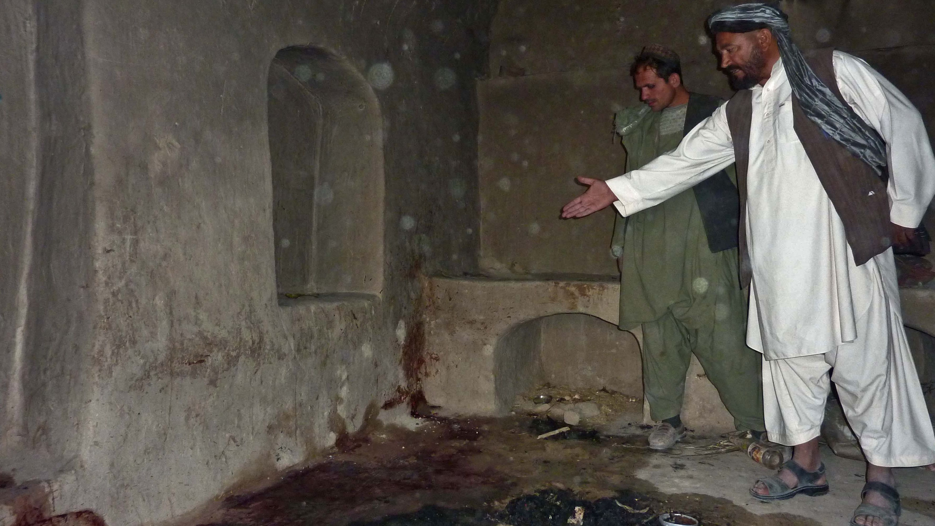 A villager points to a spot where a family was allegedly shot by a rogue U.S. soldier in Alkozai, Afghanistan.