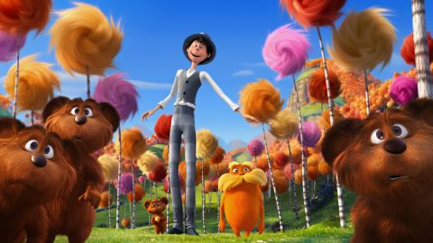 This still from the 2012 animated film shows the orange Lorax character in the center surrounded by colorful Truffula trees.