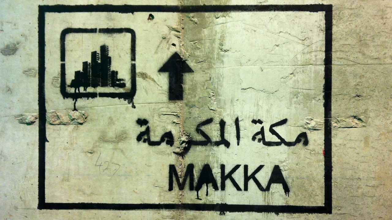 Sarah Mohanna's graffiti features a road sign to Mecca with a cluster of high-rise buildings replacing the Ka'ba shown on genuine street signs