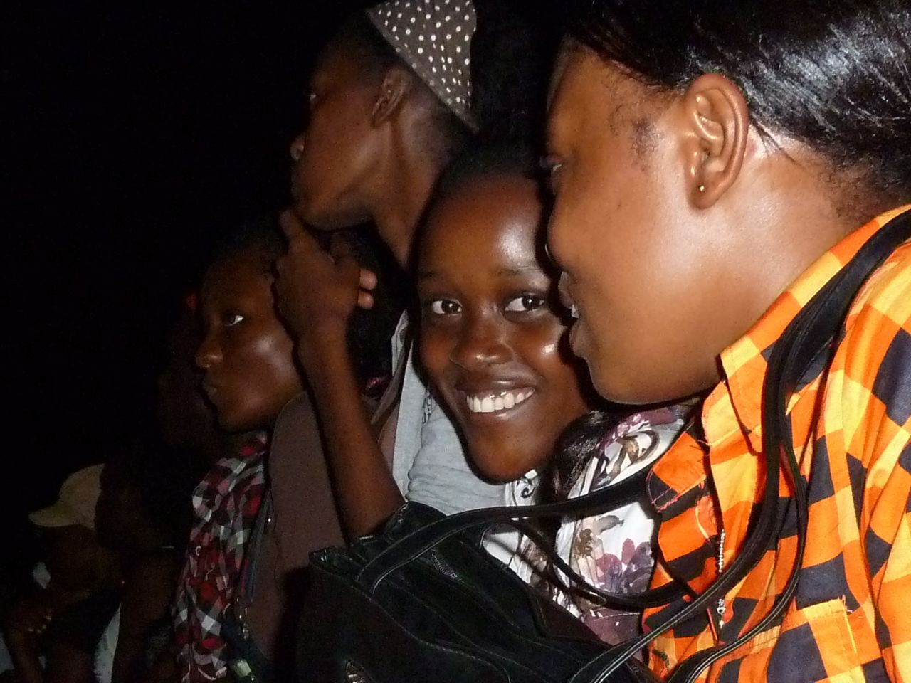 A young Gabonese girl smiles to the camera during a hip hop concert.