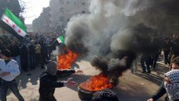 Syrian protesters burn tires and wave independence flags during an anti-regime demonstration in the Damascus suburb city of Daraya on February 4, 2012
