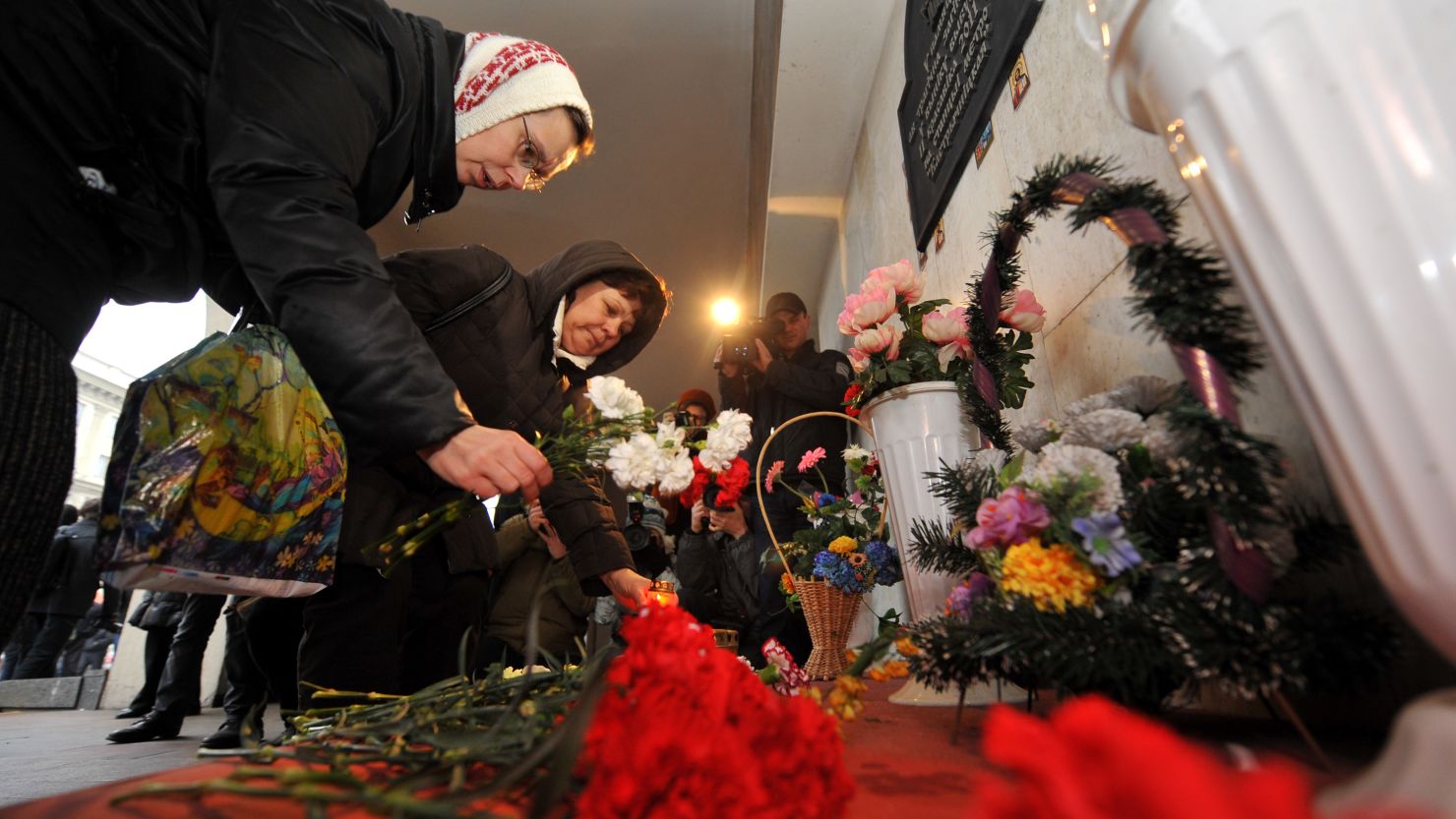 People place candles and lay flowers Friday at a memorial for the victims of last year's subway bombing in Minsk.