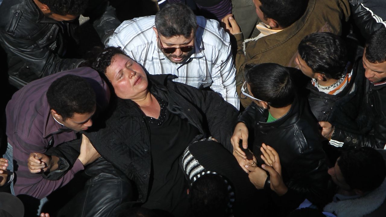 A woman faints as crowds converge on Saint Mark's Coptic Cathedral in Cairo's al-Abbassiya district, March 18, 2012.