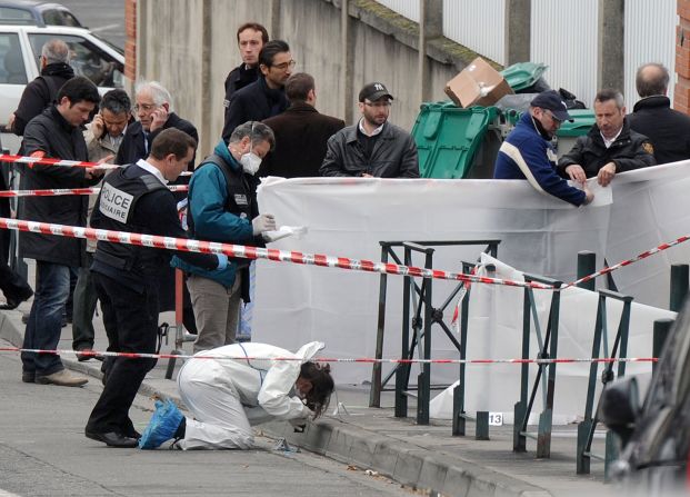 Police investigators work at the scene of the crime on Monday.  Merah was sentenced 15 times by a Toulouse juvenile court when he was a minor.