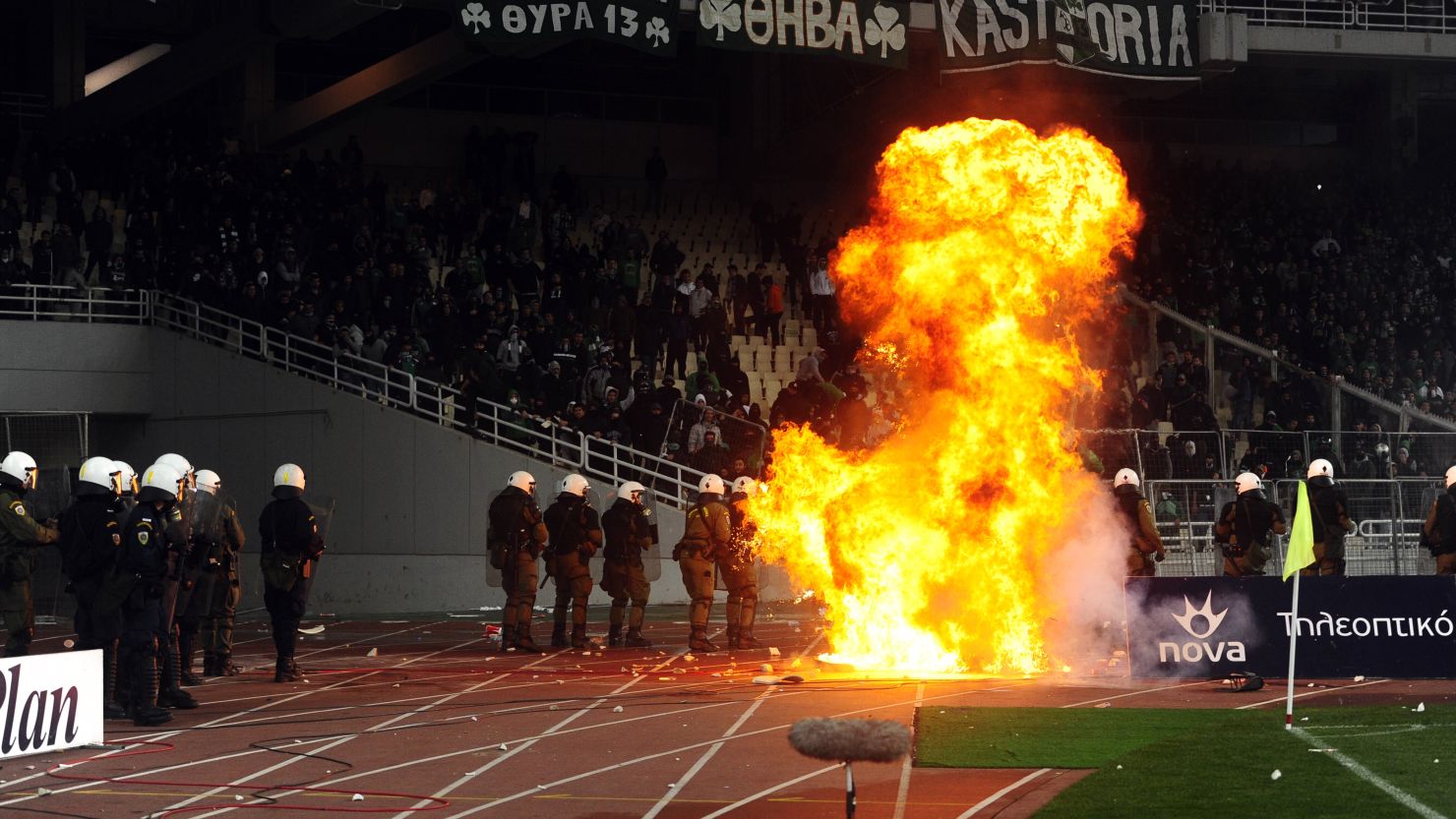 Police battle as fans riot during Olmypiakos and Panathinaikos' match at the Olympic Stadium on Sunday.