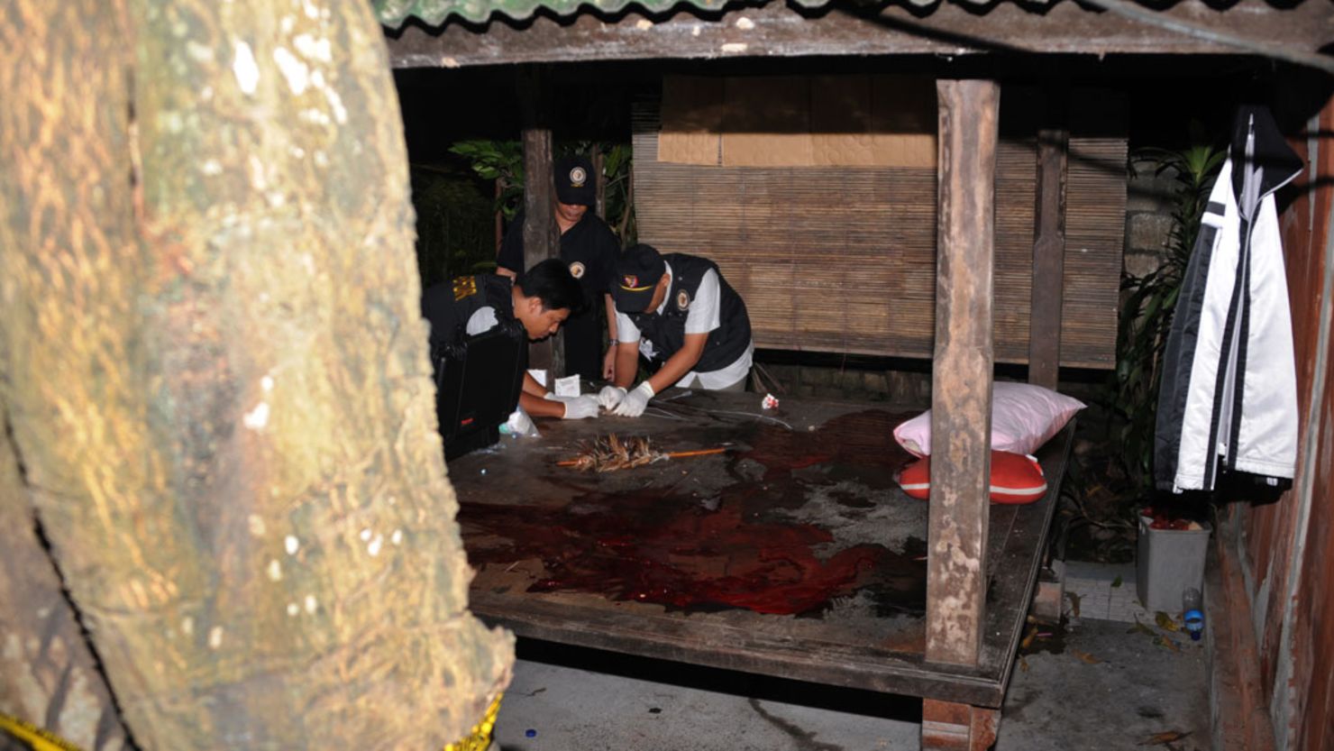 Indonesian counter-terrorism police personnel look for clues at a bungalow after the shoot-out on the island of Bali.