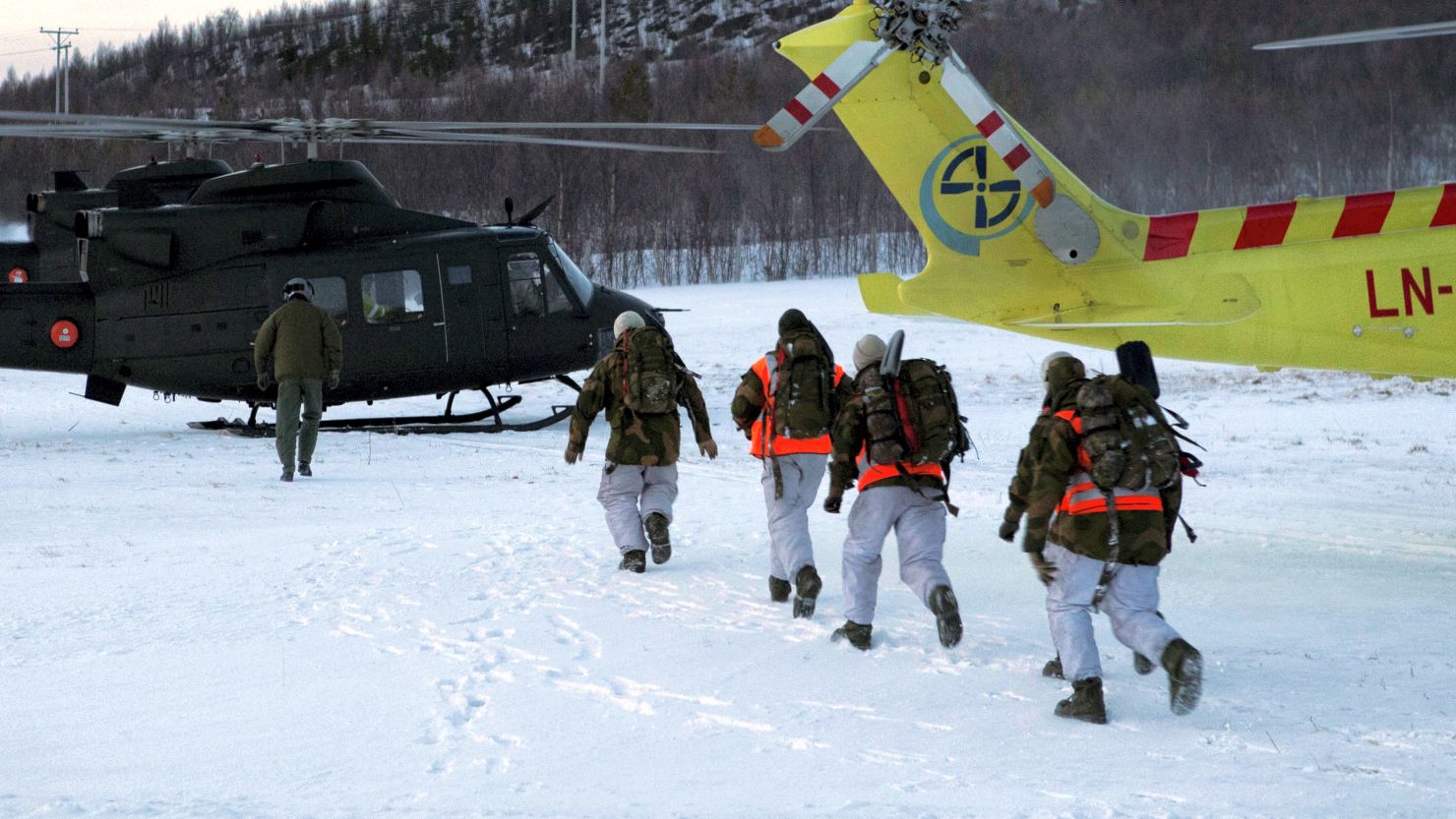 Rescuers hurry toward helicopters after a deadly avalanche Monday outside Kafjord, Norway. 