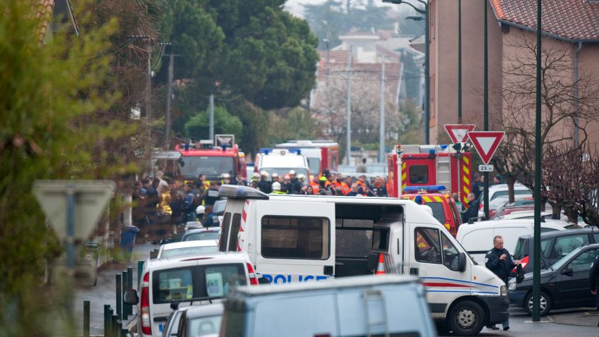 Police and members of the emergency services surround a shooting suspect's home in Toulouse.
