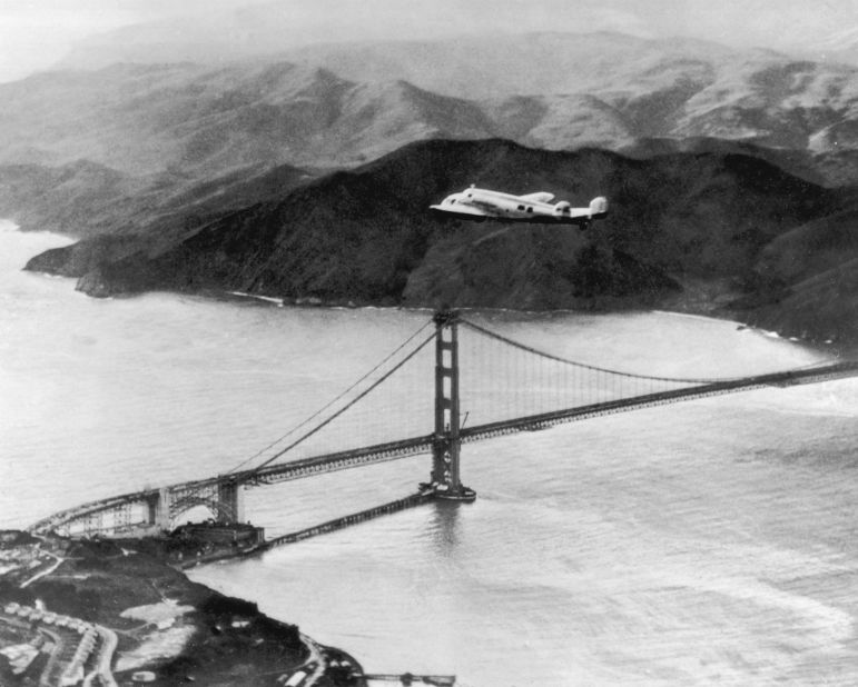 The Lockheed Electra "Flying Laboratory," piloted by Amelia Earhart, flies over the Golden Gate bridge in San Francisco, California.