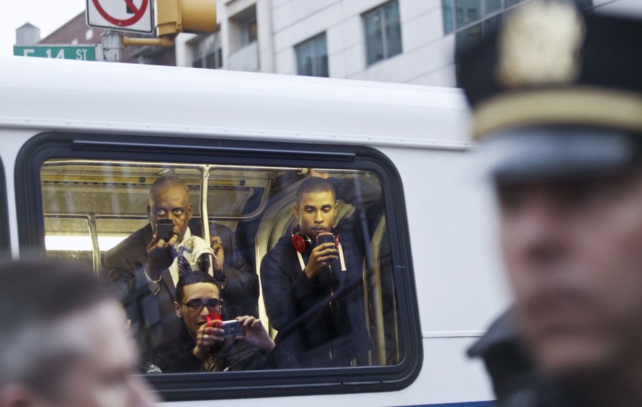 Passengers on a bus take photos of the demonstrators.