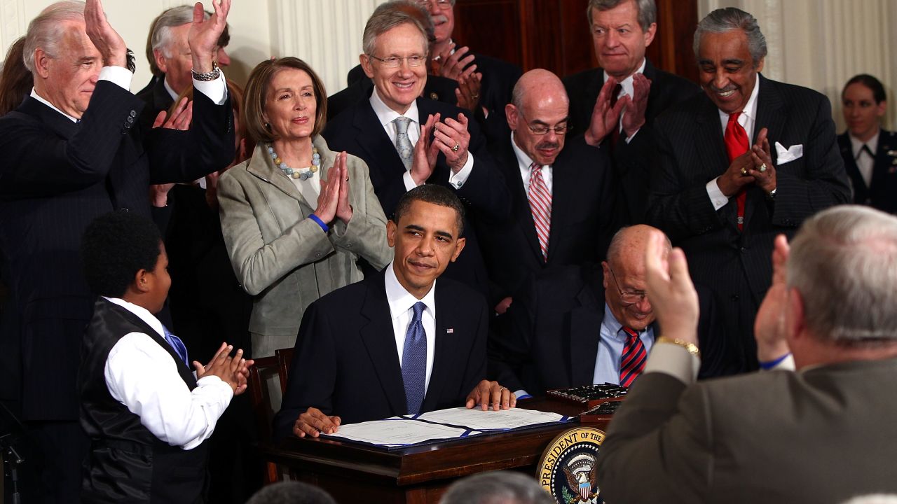 President Barack Obama is applauded after signing the Affordable Care Act at the White House in 2010.