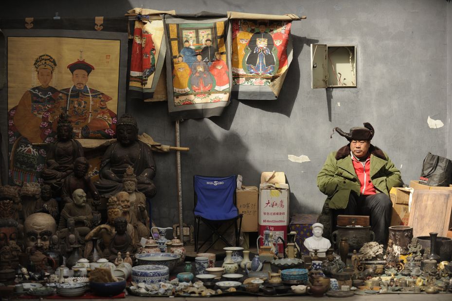 A vendor waits for customers at Panjiayuan antique market, where you can buy anything from Ming Dynasty pottery to souvenirs from the Cultural Revolution.