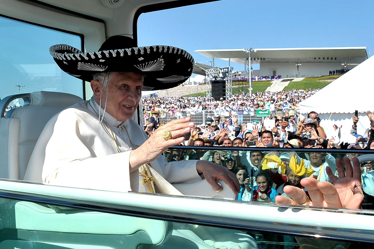 Wearing a large Mexican sombrero, Benedict waves to the crowd.