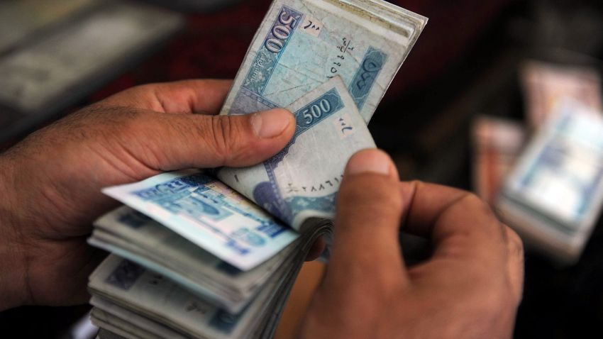 An Afghan money changer counts afghani bank notes at the exchange market in Kabul on August 10, 2011.
