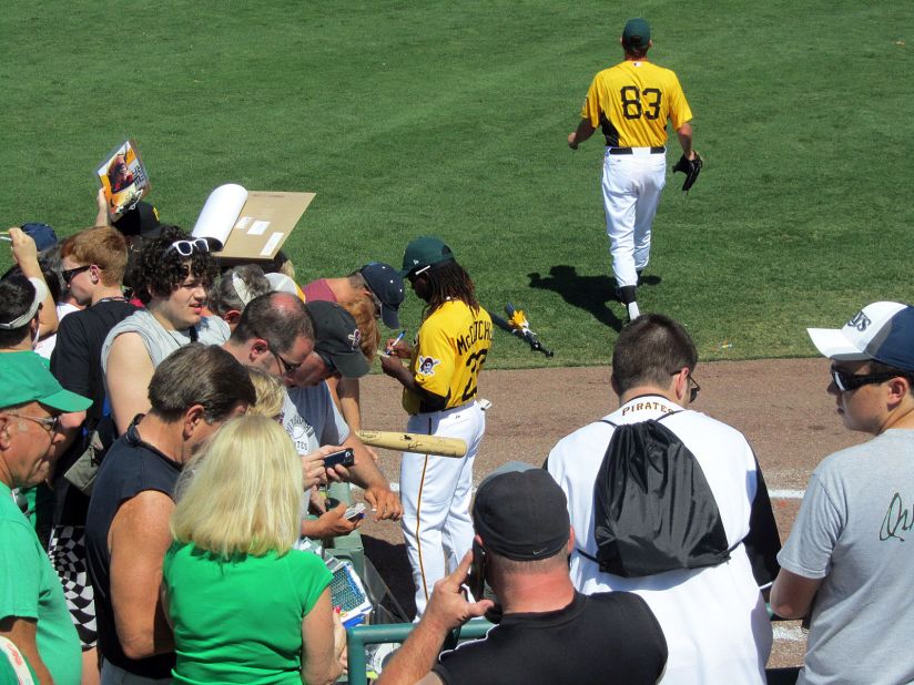 Pirates outfielder Andrew McCutchen signs memorabilia for fans before a spring training game at McKechnie Field.