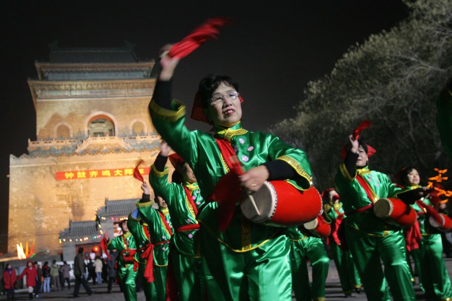 A women's drum troupe performs in front of Beijing's ancient Bell Tower, used for time keeping in Beijing for centuries.