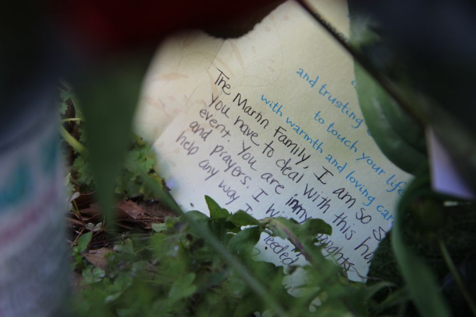 A handwritten card lies among the memorial gifts outside the neighborhood where the high schooler died.