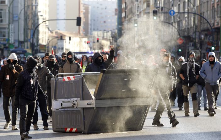 Protesters walks past a waste container in Burgos during a national strike on March 29.