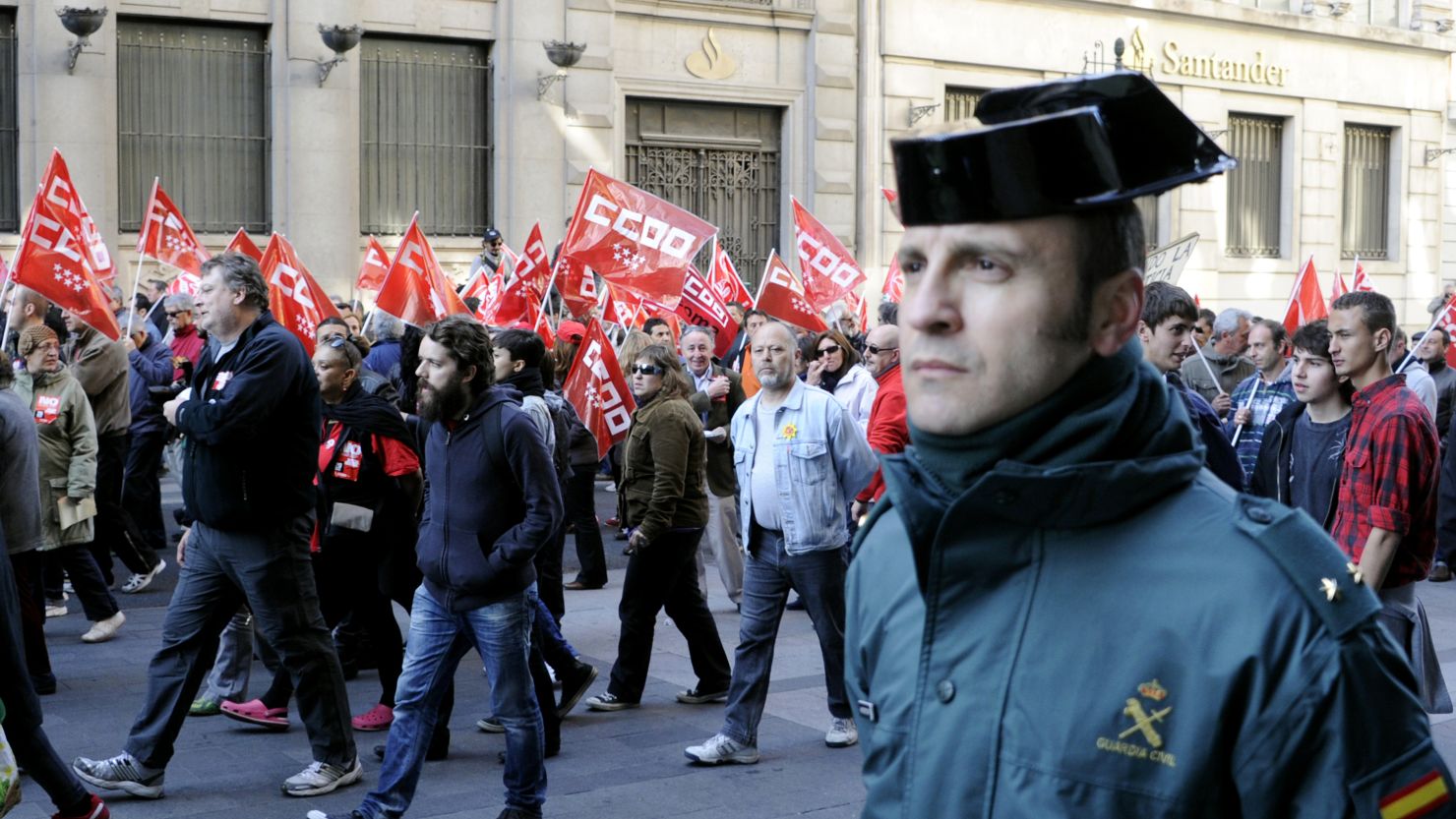 A "Guardia Civil" police officer walks along demonstrators during a day of national strike in central Madrid, Spain, on March 29.